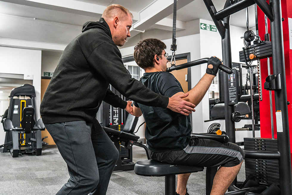 trainer helping gym member